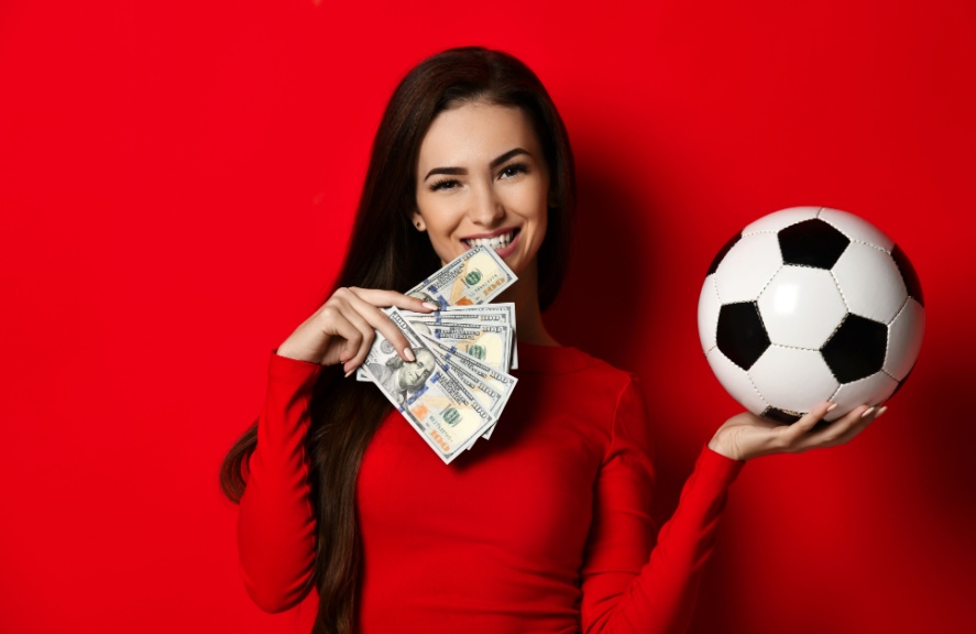 a woman holding cash and a football