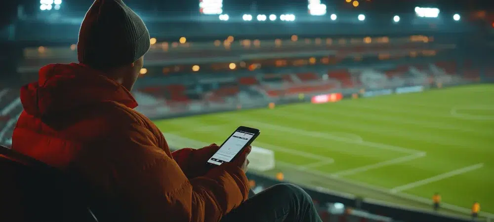 Persona con gorra apostando al fútbol en un estadio de fútbol